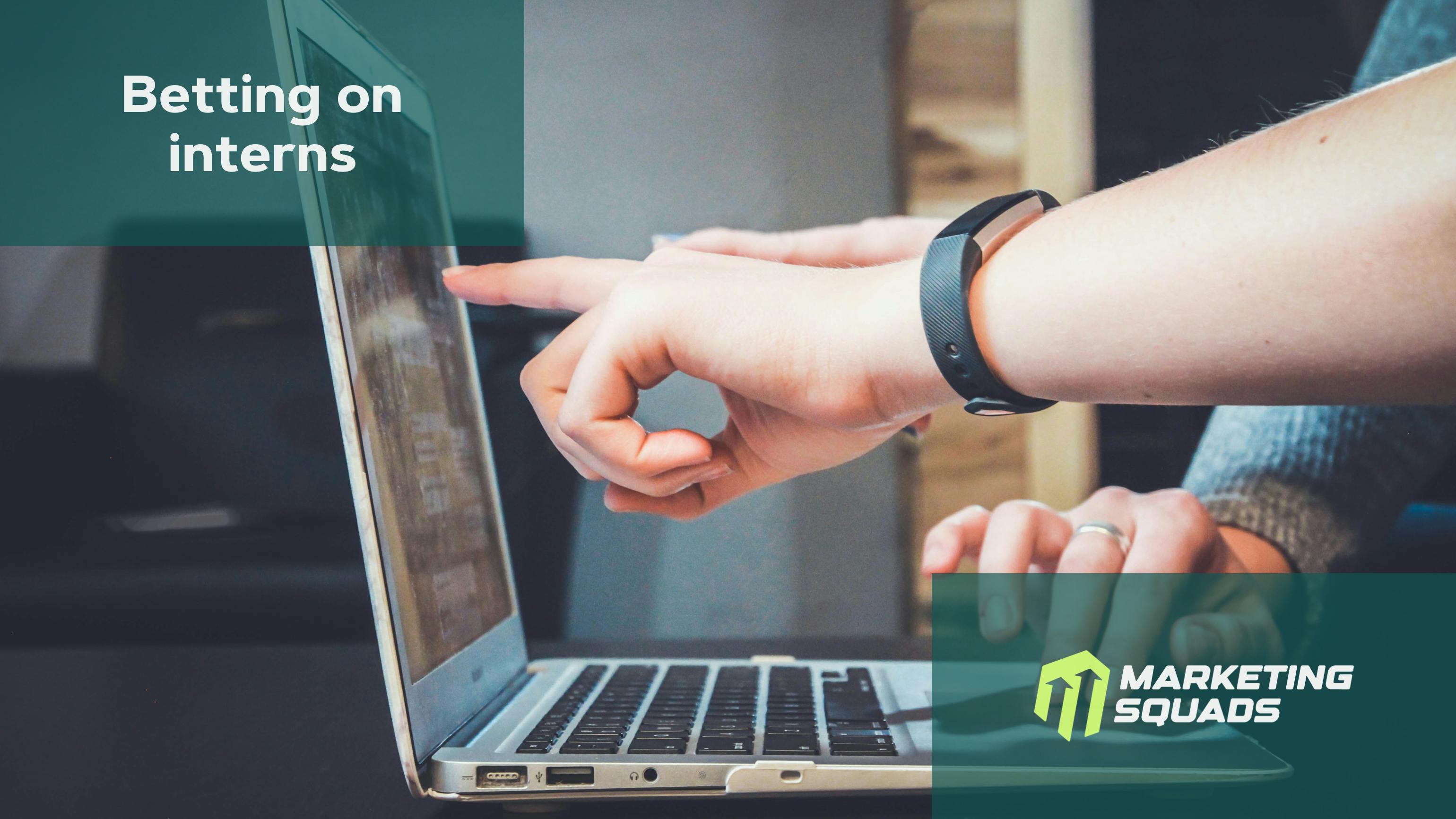 An office setting with people working. Highlight on a laptop and some pointing at the screen